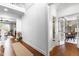 Bright hallway featuring hardwood floors, white trim, and a view into the living room and office at 4621 Basilica Dr, Holly Springs, NC 27540