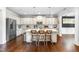 Well-lit kitchen with a large island and white cabinets and stainless steel appliances at 4621 Basilica Dr, Holly Springs, NC 27540
