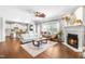 Bright living room with hardwood floors, fireplace, and an open view to the kitchen at 4621 Basilica Dr, Holly Springs, NC 27540