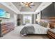 Main bedroom featuring a tray ceiling, light-filled windows, and ceiling fan at 4621 Basilica Dr, Holly Springs, NC 27540