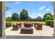 Inviting covered patio featuring comfortable wicker seating and a view of the expansive lawn and mature trees at 4621 Basilica Dr, Holly Springs, NC 27540