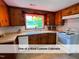 Well-lit kitchen featuring custom cabinets, a white appliance package, and a garden window at 4720 Rivermont Rd, Durham, NC 27712
