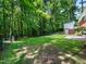 A large backyard with a border of mature trees for privacy on a sunny day at 4909 Brookhaven Dr, Raleigh, NC 27612