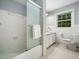 Classic bathroom with white tile, shower, and ample natural light from the large window at 4909 Brookhaven Dr, Raleigh, NC 27612