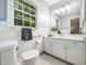 Neat bathroom with white tile, a large window, and classic fixtures at 4909 Brookhaven Dr, Raleigh, NC 27612