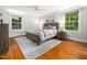 Bright bedroom with large windows, a wooden bed frame, and light colored walls at 4909 Brookhaven Dr, Raleigh, NC 27612