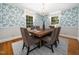 Chic dining room with designer wallpaper and hardwood floors at 4909 Brookhaven Dr, Raleigh, NC 27612