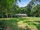 Ranch-style home with lush green lawn and mature trees at 4909 Brookhaven Dr, Raleigh, NC 27612