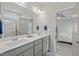 Bright bathroom featuring a double sink vanity with modern fixtures and a doorway view of the bedroom at 509 Rain Drizzle Ct, Wake Forest, NC 27587
