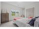 Cozy bedroom with a plush bed, a dresser and a view of the green outdoors through the window at 509 Rain Drizzle Ct, Wake Forest, NC 27587