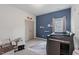 Charming Bedroom with blue accent wall, a crib, glider and a view of the window at 509 Rain Drizzle Ct, Wake Forest, NC 27587