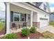 Charming front porch featuring seating, a wreath on the front door, and a well-manicured landscape at 509 Rain Drizzle Ct, Wake Forest, NC 27587