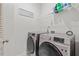 Modern laundry room with front-load washer and dryer, and a shelving unit above at 509 Rain Drizzle Ct, Wake Forest, NC 27587