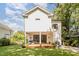 Rear view of a home showcasing a covered patio, manicured lawn, and backyard landscaping at 517 Bart St, Raleigh, NC 27610
