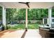 Beautiful backyard with a covered deck, a fire pit, lush lawn, and mature trees offering privacy at 517 Bart St, Raleigh, NC 27610