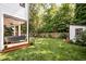 Expansive backyard featuring a covered porch, well-maintained lawn, privacy fence, and a storage shed at 517 Bart St, Raleigh, NC 27610