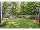Expansive backyard showcasing a lush lawn, outdoor dining area, fire pit, and mature landscaping for privacy at 517 Bart St, Raleigh, NC 27610