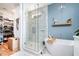 Spa bathroom featuring a glass-enclosed shower, soaking tub, and walk-in closet entrance at 517 Bart St, Raleigh, NC 27610