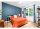 Inviting bedroom with modern decor, a large window, and a blue accent wall at 517 Bart St, Raleigh, NC 27610