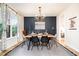 Modern dining room with stylish lighting, a navy accent wall, and a rustic wood table at 517 Bart St, Raleigh, NC 27610