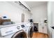 Functional laundry room featuring modern washer and dryer, storage shelves, and counter space at 517 Bart St, Raleigh, NC 27610