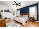 Comfortable main bedroom with a wooden bed frame, blue accent wall, and hardwood floors at 517 Bart St, Raleigh, NC 27610