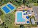 An aerial shot showcases a pool, tennis courts, playground, and parking area at 5603 Whisperwood Dr, Durham, NC 27713