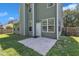 Home's back exterior with multiple windows, white door, and concrete patio at 5603 Whisperwood Dr, Durham, NC 27713