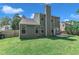 Backyard view of the green home featuring a chimney and an expansive lawn at 5603 Whisperwood Dr, Durham, NC 27713