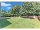 Spacious backyard featuring a large lawn, a patio area, and a wood fence at 5603 Whisperwood Dr, Durham, NC 27713