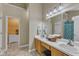Bathroom featuring double sinks, a large mirror, and a doorway to a walk-in closet at 5603 Whisperwood Dr, Durham, NC 27713