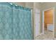 Bright bathroom featuring patterned shower curtain, neutral walls, and access to closet at 5603 Whisperwood Dr, Durham, NC 27713