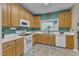 Charming kitchen features ample cabinet space, white appliances, and natural light from the window at 5603 Whisperwood Dr, Durham, NC 27713