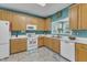 Bright kitchen featuring white appliances, wood cabinets, and a garden window at 5603 Whisperwood Dr, Durham, NC 27713