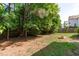 Large backyard featuring a fire pit, green grass, and mature trees at 6004 Solitude Way, Durham, NC 27713