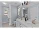 Bathroom featuring a dual sink vanity, large mirror, and a window bringing in natural light at 6004 Solitude Way, Durham, NC 27713