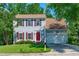 Charming two-story home featuring gray siding, a red door, and well-maintained landscaping at 6004 Solitude Way, Durham, NC 27713