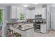 Bright kitchen features white cabinets, modern appliances, and a breakfast bar at 6004 Solitude Way, Durham, NC 27713