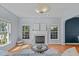 Cozy living room with a fireplace, large windows, and hardwood floors at 6004 Solitude Way, Durham, NC 27713