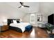 This primary bedroom features hardwood floors, a ceiling fan, natural light, and a sitting area at 6313 Belle Crest Dr, Raleigh, NC 27612