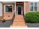 Inviting front entrance features brick steps, black railing and tidy landscaping at 6313 Belle Crest Dr, Raleigh, NC 27612