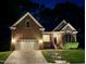 Beautifully lit brick home at night with a well-manicured lawn at 6313 Belle Crest Dr, Raleigh, NC 27612