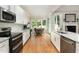 Modern kitchen with stainless steel appliances and an open view into the dining area at 6313 Belle Crest Dr, Raleigh, NC 27612