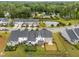 Expansive aerial view of a modern neighborhood with green spaces and a pond, showcasing a serene community setting at 640 Barneswyck Dr, Fuquay Varina, NC 27526