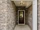 Inviting entryway featuring stone walls, a modern light fixture, and a glass-paneled front door at 640 Barneswyck Dr, Fuquay Varina, NC 27526