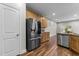 Open kitchen design with stainless steel appliances, wood cabinetry, granite countertops, and modern wood flooring at 640 Barneswyck Dr, Fuquay Varina, NC 27526