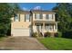 Charming two-story home features a two-car garage, welcoming front porch and a well-maintained lawn at 6701 Winding Arch Dr, Durham, NC 27713