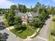 Aerial view of stunning home with manicured lawn, mature trees and lush landscaping on a corner lot at 705 Harkness Cir, Durham, NC 27705