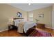 Cozy bedroom features a wooden bed frame with white bedding and decorative pillows with side tables and accent rug at 705 Harkness Cir, Durham, NC 27705