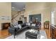 Expansive living room boasts hardwood floors, open staircase, and seamless access to other spaces at 705 Harkness Cir, Durham, NC 27705